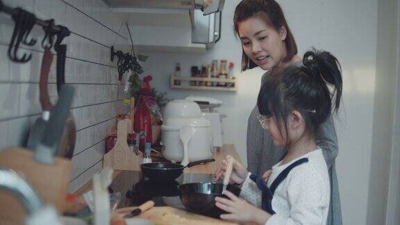 可爱的小女孩在家和妈妈一起做饭