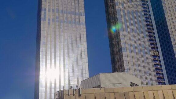 三座摩天大楼的坚固玻璃表面反射着阳光