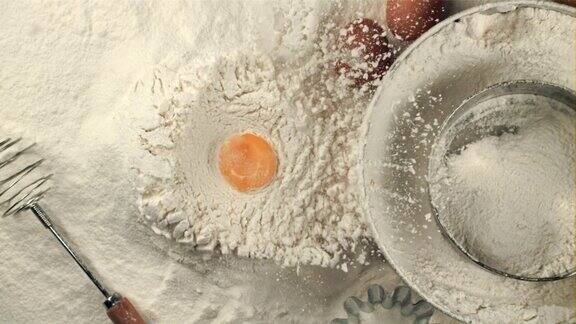 超级慢动作的鸡蛋掉进桌上的一堆面粉里在高速相机拍摄1000帧每秒