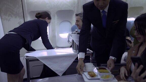 空中小姐在飞机上为乘客提供食物和饮料