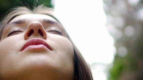 低角度拍摄女人的脸闭着眼睛冥想感觉与自然统一