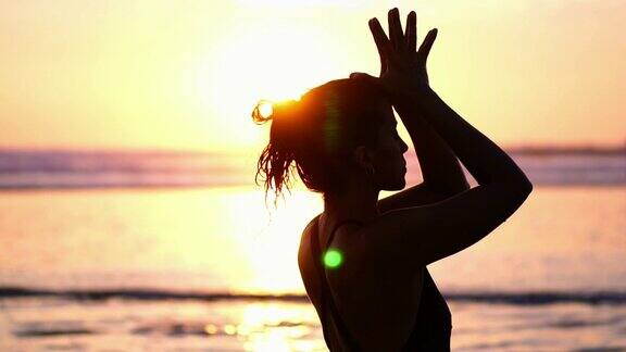 年轻健康的女人瑜伽运动在海滩上
