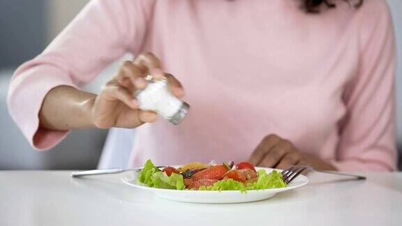 妇女在食物中添加太多盐不健康的饮食脱水问题