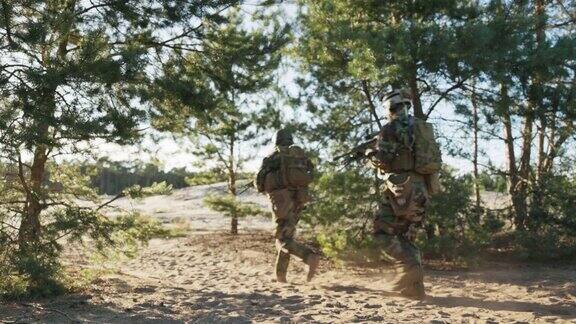士兵们在沙地上、在树林中的训练场上列队奔跑手持步枪穿着制服戴着头盔保卫领土进行军事演习进行挑衅