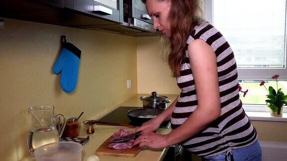 孕妇在砧板上用刀切鲜肉