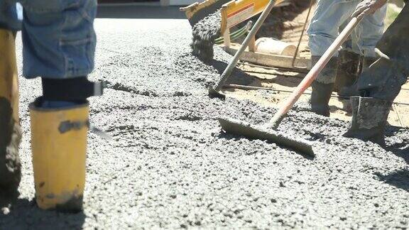 混凝土工人正在浇筑和铲平新车道