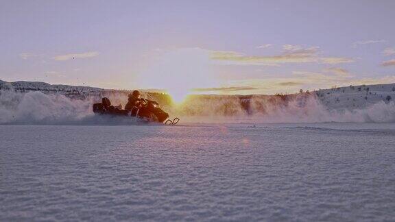 挪威日落时分游客们骑着雪地摩托