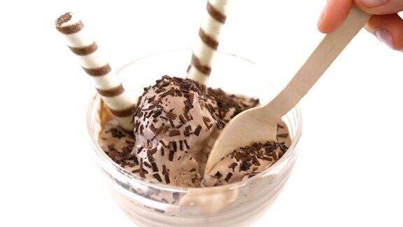 冰淇淋碗里的冰淇淋上面装饰有威化饼卷用木勺舀冰淇淋