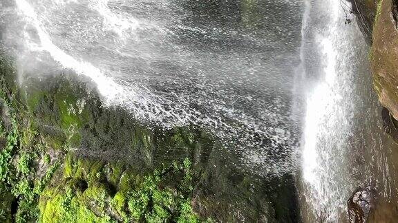 瀑布从岩石悬崖上倾泻而下水流从岩石上落在石头上慢动作