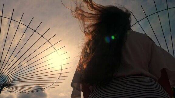 飘扬的头发在风中在夕阳下在阳光下长发飘动的浪漫女孩的剪影慢动作