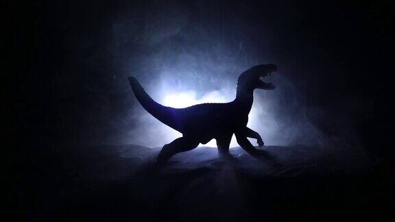 迷雾之夜巨型恐龙的剪影创意小微缩装饰燃烧的模糊背景有选择性的重点