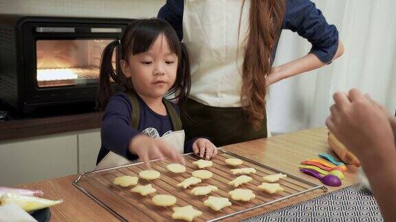 日本女儿数着托盘上的饼干准备好后与亚洲母亲哥哥亚洲家庭与两个孩子做饭烘焙烘焙有积极情绪的孩子