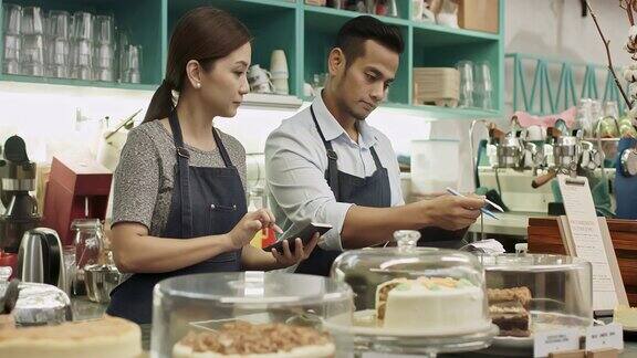 一对马来商业夫妇在咖啡店工作检查当天的收据