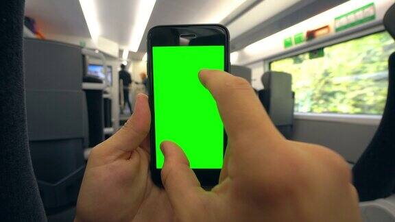 在火车上拿着绿色屏幕的手机