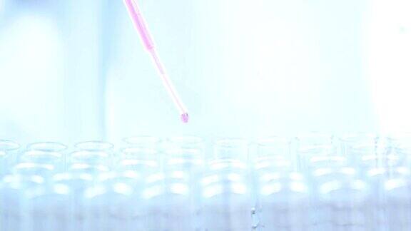 科学家穿着白色防护服用吸管在实验室进行科学实验时将化学物质注入试管