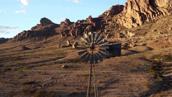 航拍:在阳光明媚的岩石山沙漠中飞过古老的风车