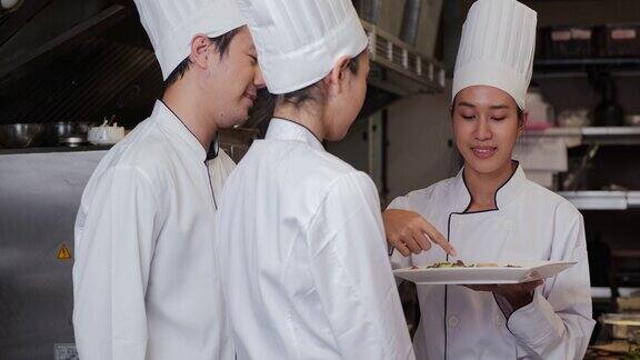 快乐女厨师与团队交谈的肖像厨师和厨师准备食物在酒店餐厅