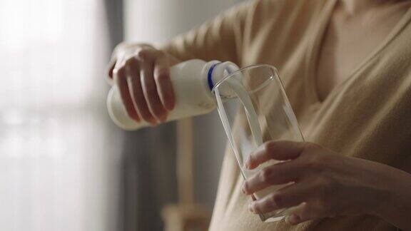 慢镜头女人往杯子里倒牛奶