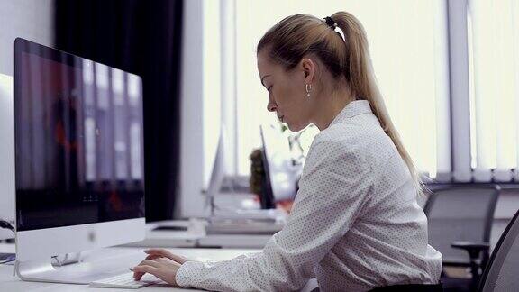 美丽的女商人在办公室里用电脑工作