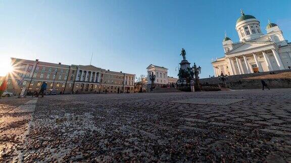 时间流逝:游客聚集在赫尔辛基参议院广场广场上有亚历山大二世的雕像
