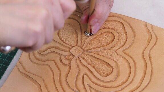 工匠印章浮雕花在皮革上与背景冲压工具