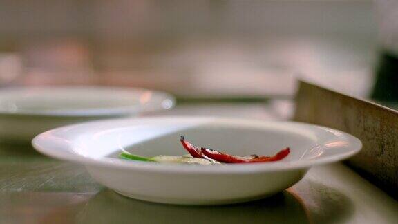 厨师用盘子盛了些熟辣椒