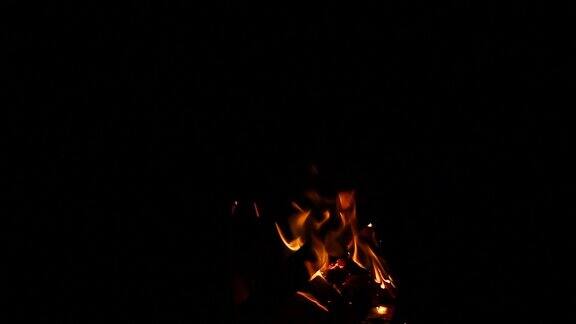 小篝火与砍过的木头在一个黑色的背景特写火焰孤立自然背景与小火花