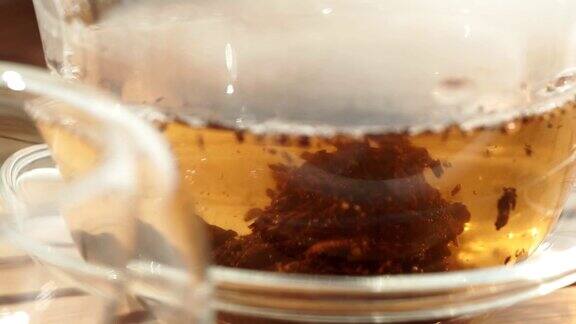 茶壶将红茶倒入玻璃杯中特写微距选择性聚焦