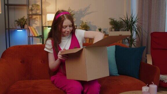 快乐童女采购员打开纸板箱快递包裹网上购物在家里购买