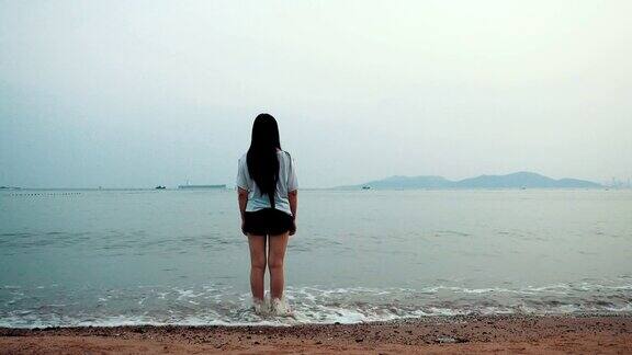 一个年轻女子独自走在海滩上