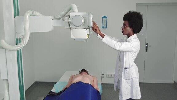 在医院男人躺在床上女技术员调整x光机扫描骨折断肢受伤癌症或肿瘤