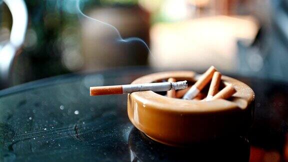 陶瓷烟灰缸上的香烟燃烧着冒烟