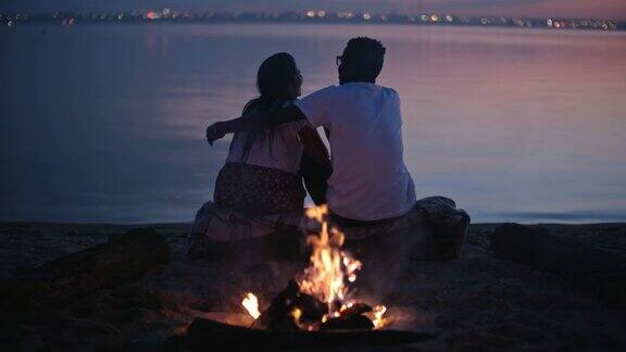 黄昏时分一对情侣在海滩上欣赏风景
