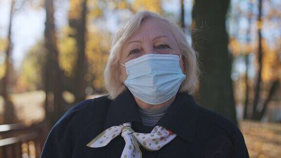 新冠肺炎疫情期间公园里戴着防护口罩的资深女性肖像