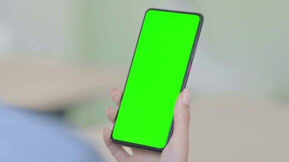 女性使用智能手机与绿色色度键屏幕的特写