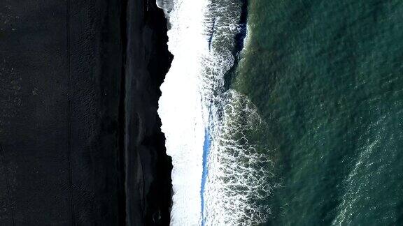 海浪拍打黑色海滩的4k空中视频