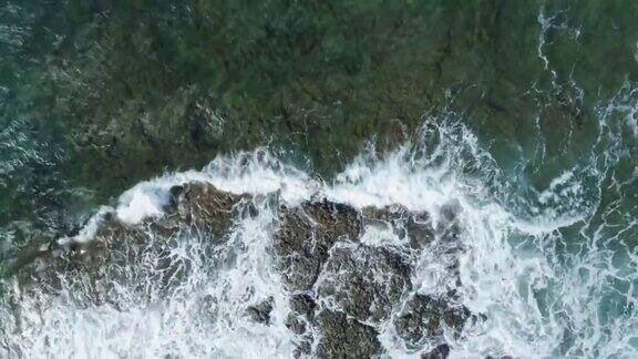 空中缩放镜头的海浪冲刷岩石