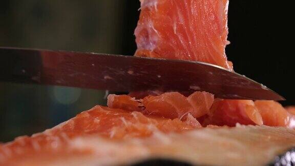 用锋利的刀切下大片的红鱼咸鱼鲑鱼在家里烹饪寿司的慢动作视频