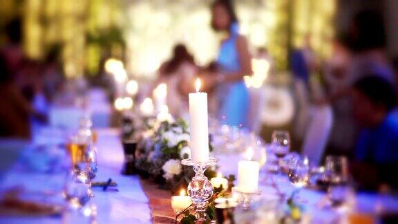 婚礼装饰用鲜花和蜡烛在桌子上为客人