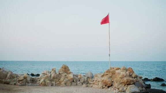在晴朗的天空下红旗在海边飘扬