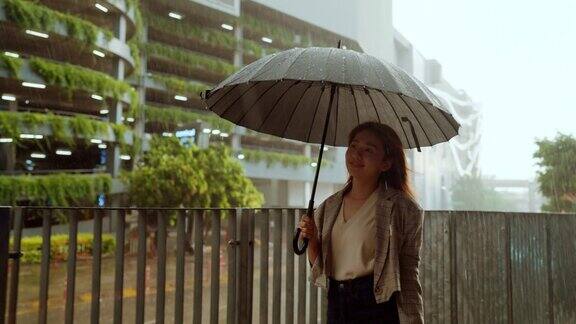 在大雨中撑着伞的女商人孤独而忧伤