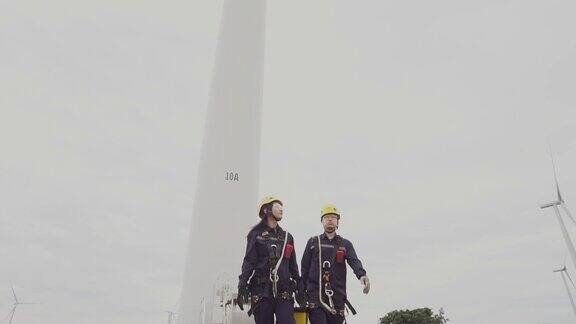 两名亚洲工程师检查工程师准备和进度检查一个风力涡轮机与安全在泰国风电场
