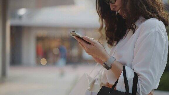 女人用智能手机购物袋