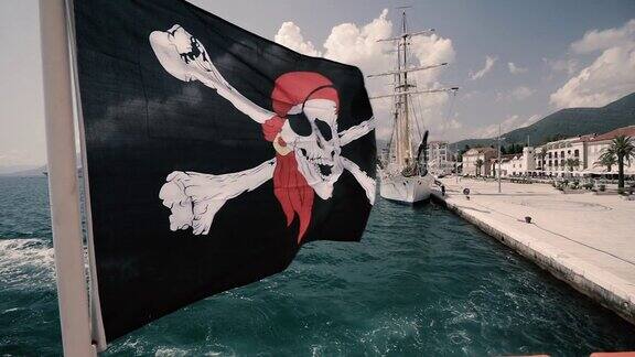 一面海盗旗在驶离码头的船只的风中飘扬