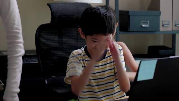 亚洲姐弟在家里用笔记本电脑玩网络游戏时聊天、玩乐维系和分享爱的家庭