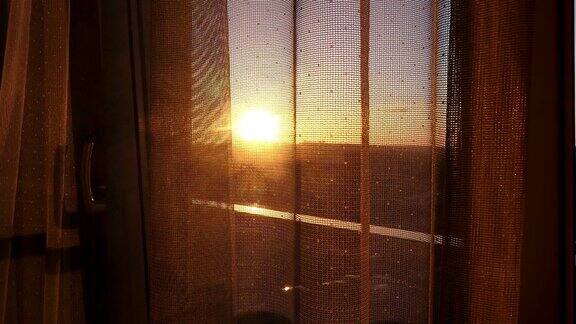 透过透明窗帘看窗外的日落