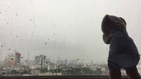 孤独的泰迪熊带着雨滴在窗前哭泣的画面