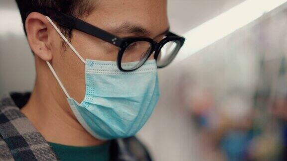 新冠肺炎疫情期间亚洲年轻人在地铁上佩戴蓝色防护口罩