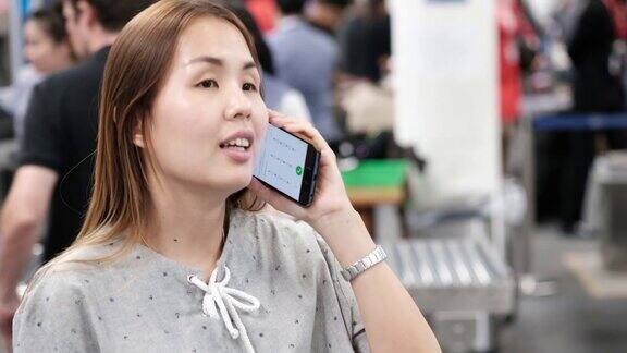 亚洲游客在机场使用电话