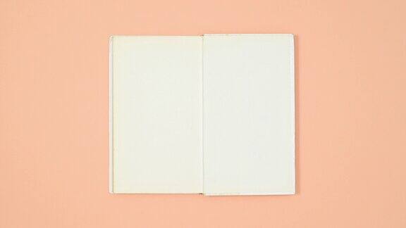 白色精装书出现在包装纸和打开橙色的主题止动平铺